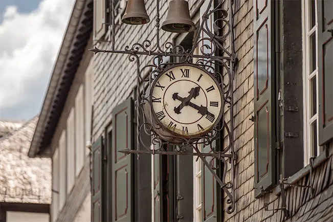 Decorative antique clock mounted on the exterior of a historic building