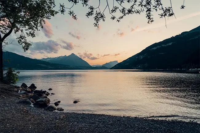 Mountain lake at sunset with a rocky shoreline