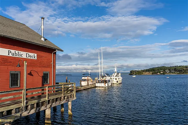 Red waterfront building and boats overlooking a calm harbor