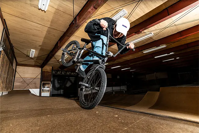 BMX rider performing a trick inside an indoor skate park