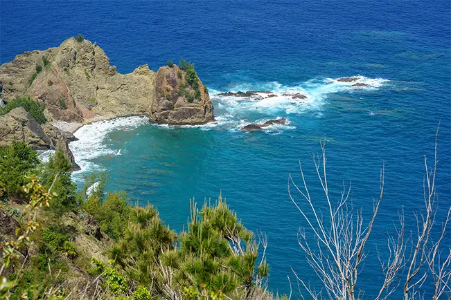 Rocky coastline surrounded by bright blue ocean water