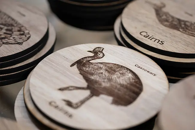 Wooden coaster featuring an engraved cormorant illustration
