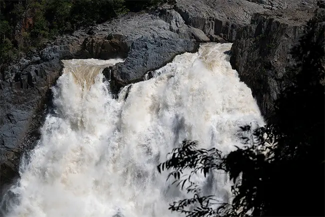 Waterfall cascading over rocks surrounded by lush greenery