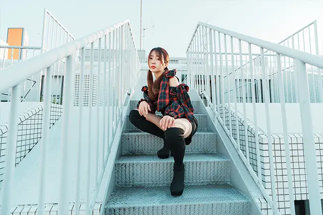 Woman sitting on a metal staircase in an urban setting
