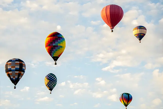 Colorful hot air balloons floating in a blue sky