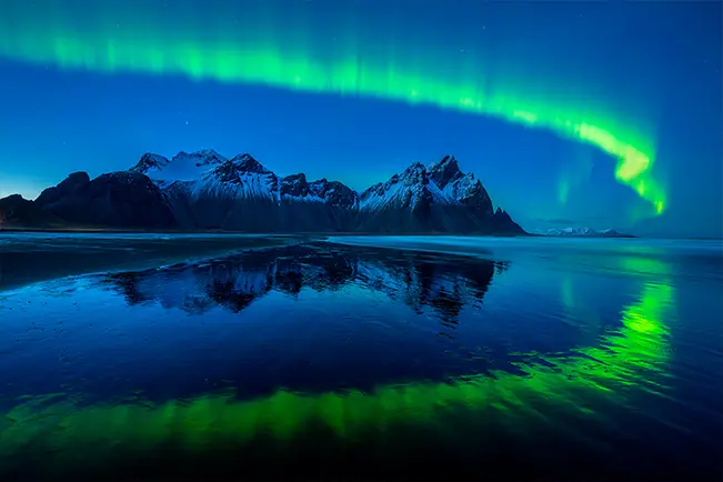 Northern lights over a mountain lake