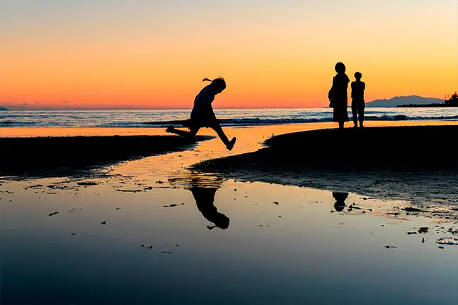 People enjoying a beach at sunset